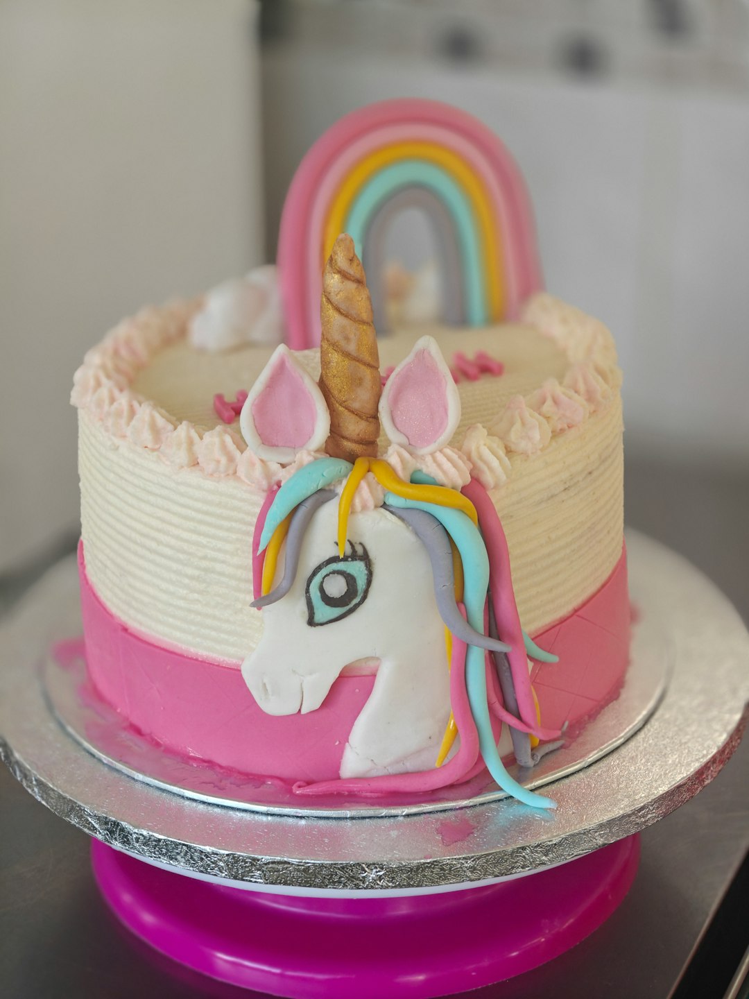 A unicorn cake with a rainbow on top